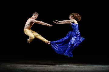 Fotobehang Dancing couple in the darkness, bounce in the dance movement. © Alexander