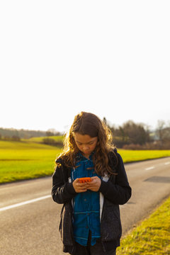 Girl using the phone on the street, danger