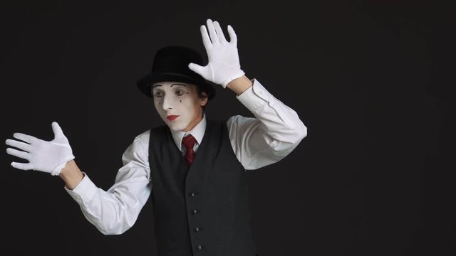 The mime is behind an invisible wall. Black background