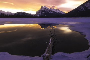 Scenic view of snowcapped mountains and lake at sunset