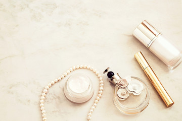 Beauty products and accessories top view on white marble background. 