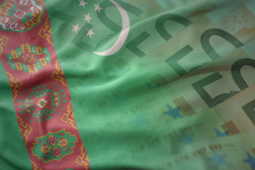 colorful waving national flag of turkmenistan on a euro money banknotes background. finance concept