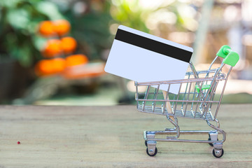 credit card and cart or trolley on wood