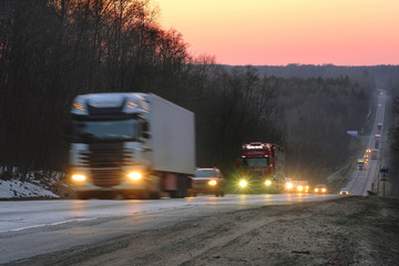 Trucks on a highway in an evening