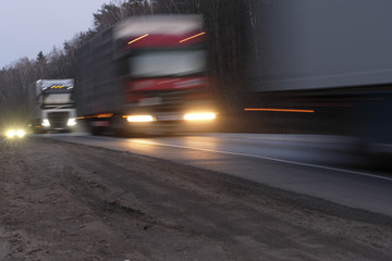 Trucks on a highway in an evening