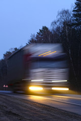 Fototapeta na wymiar Trucks on a highway in an evening