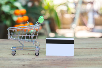 credit card and cart or trolley on wood