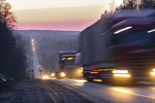 Trucks on a highway in an evening