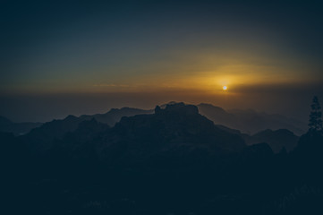 Beautiful view of amazing tropical scenery with mountain valleys above wide open sea in golden evening light at sunset with blue sky and clouds in summer, Canary Islands, Spain