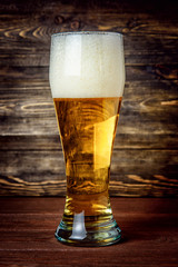 Glass of light beer on a pub with bokeh background