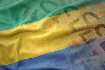 colorful waving national flag of gabon on a euro money banknotes background. finance concept