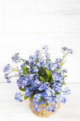blue flowers bouquet on white wooden background