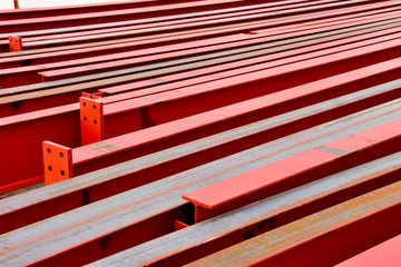 Rows of steel I beams ready for installation at nearby construction site.