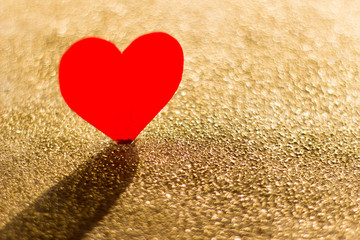Cardboard heart on a gold background, abstract