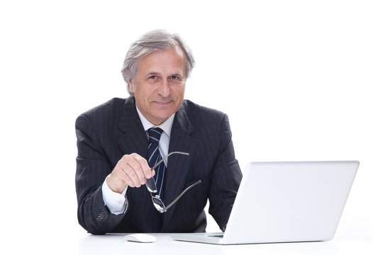smiling senior businessman isolated on white using laptop