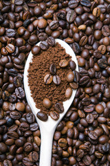 Iinstant coffee in spoon on coffee beans background