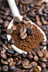 Iinstant coffee in spoon on coffee beans background