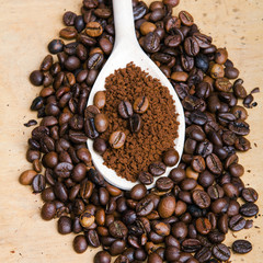 Iinstant coffee in spoon on coffee beans background