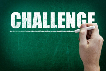 Hand writing the text CHALLENGE on the blackboard