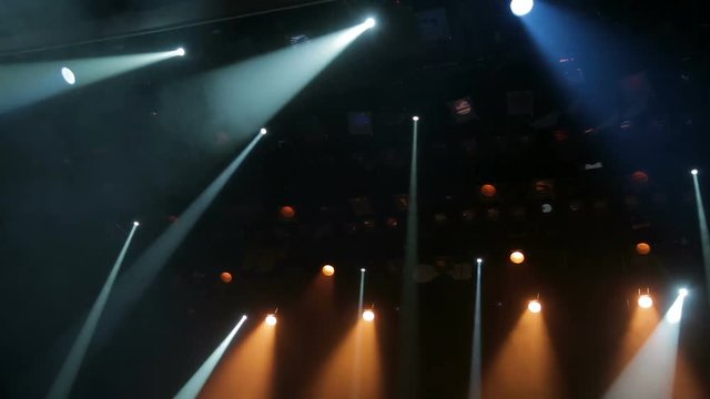 Floodlights, head, scanners, the theatrical smoke on the stage of the theatre during the performance. Lighting equipment. The lighting effects. Dynamic light.