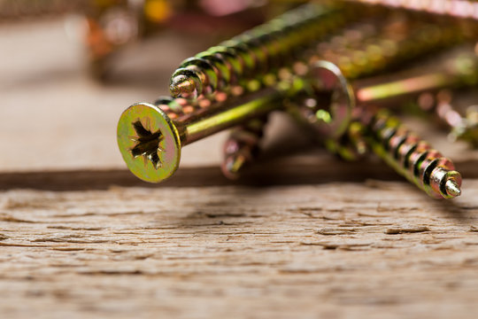 Close up image of screws and nails on a wooden surface ready for use in a DIY project