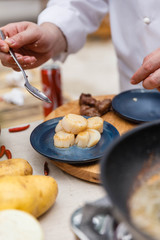 Chef Plating Fried Scallops in Blue Ceramic Plate.