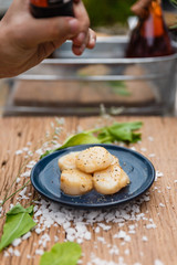 Fried Scallops Topping with Pepper on Blue Ceramic Plate on Wood Panel with Sea Salt and Vegetable Decorated.