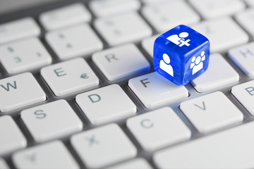 Blau farbener / blauer Würfel auf Tastatur mit Zeichen für Benutzer & Personen und neuer Nutzer