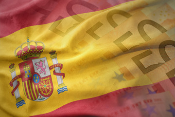 colorful waving national flag of spain on a euro money banknotes background. finance concept