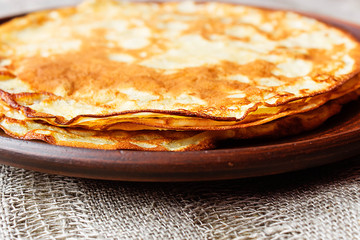 Maslenitsa, traditional Russian pancakes -  blini on a plate of dark clay.