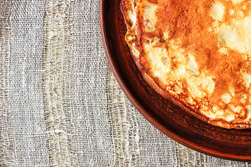 Maslenitsa, traditional Russian pancakes -  blini on a plate of dark clay.