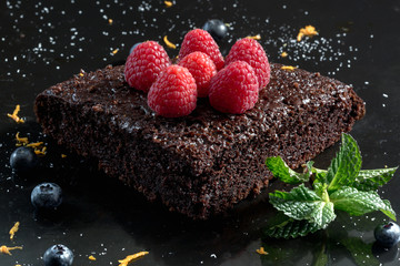 Chocolate cake with raspberries, blueberries, orange zest and pipermint