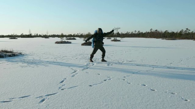 Young man dances on the frozen lake