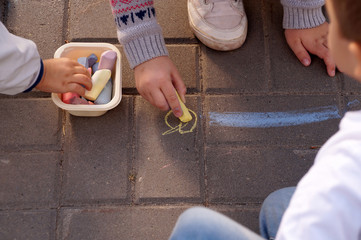 Drawing by pieces of chalk on asphalt in city park