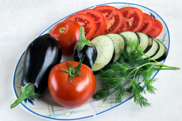 Tomato and aubergine, sliced. Fresh dill. Preparation of a vegetable dish ratatouille.