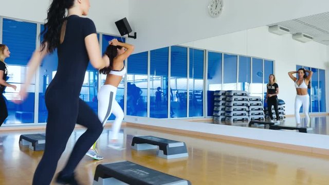 The sporty women training step aerobics in gym with step