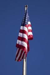 The American flag on a blue sky background 