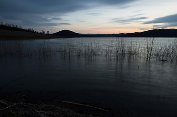 Beautiful image of a lake at dusk, with soft colors and dark shadows