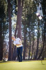 Naklejka premium Close up view of a golfer playing a chip shot on a golf course in south africa with back light.