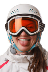 A young snowboard girl wearing a helmet and glasses put out her tongue