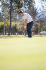 Close up view of a golfer playing a chip shot on a golf course in south africa with back light.