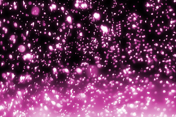 Magic festive pink particles isolated on black background. Bokeh light and sparkles. Abstract glitter lights