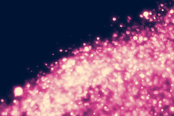 Fototapeta na wymiar Magic festive pink particles isolated on black background. Bokeh light and sparkles. Abstract glitter lights