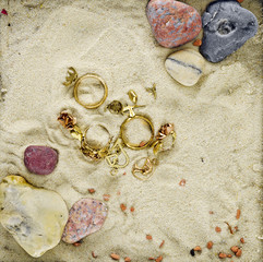 Obraz na płótnie Canvas gold jewelry in a scenery with sand