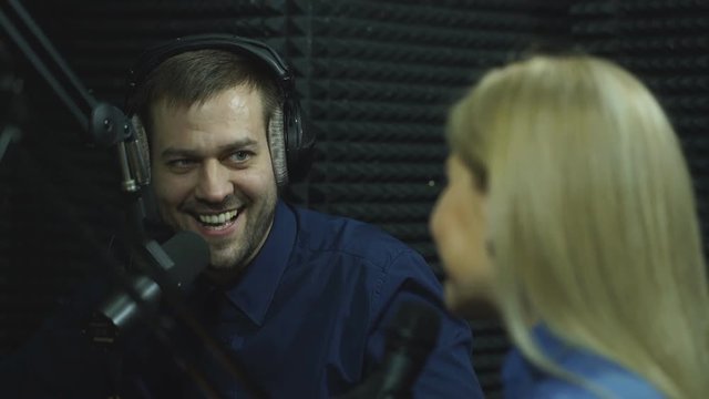 Presenters or moderators - man and woman - in radio station hosting show for radio live in Studio