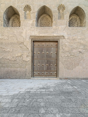 Wooden aged vaulted door and stone wall, Medieval Cairo, Egypt	