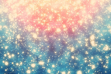 Abstract round gold bokeh or glitter lights on blue and red background. Circles defocused particles and rays