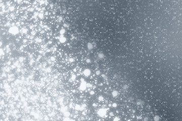 Snowflakes rays and bokeh or glitter lights on silver background. Christmas abstract template