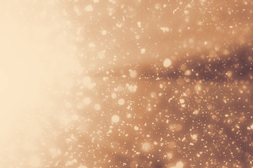 Golden rays and sparkles or glitter lights. Merry Christmas festive gold background.defocused circle bokeh or particles