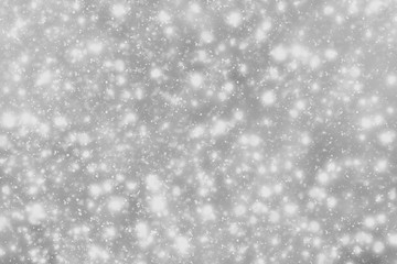 Snowflakes particles and bokeh or glitter lights on silver background. Christmas abstract template